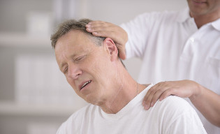 Ένας άντρας με οστεοχόνδρωση του λαιμού κατά τη λήψη ενός χειροκίνητου μασέρ